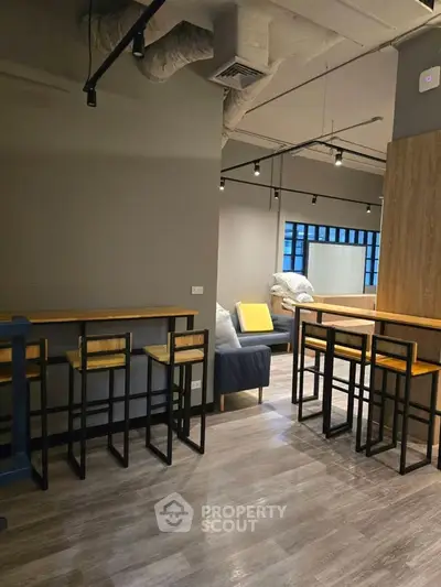 Modern industrial-style living room with high ceilings and sleek furniture
