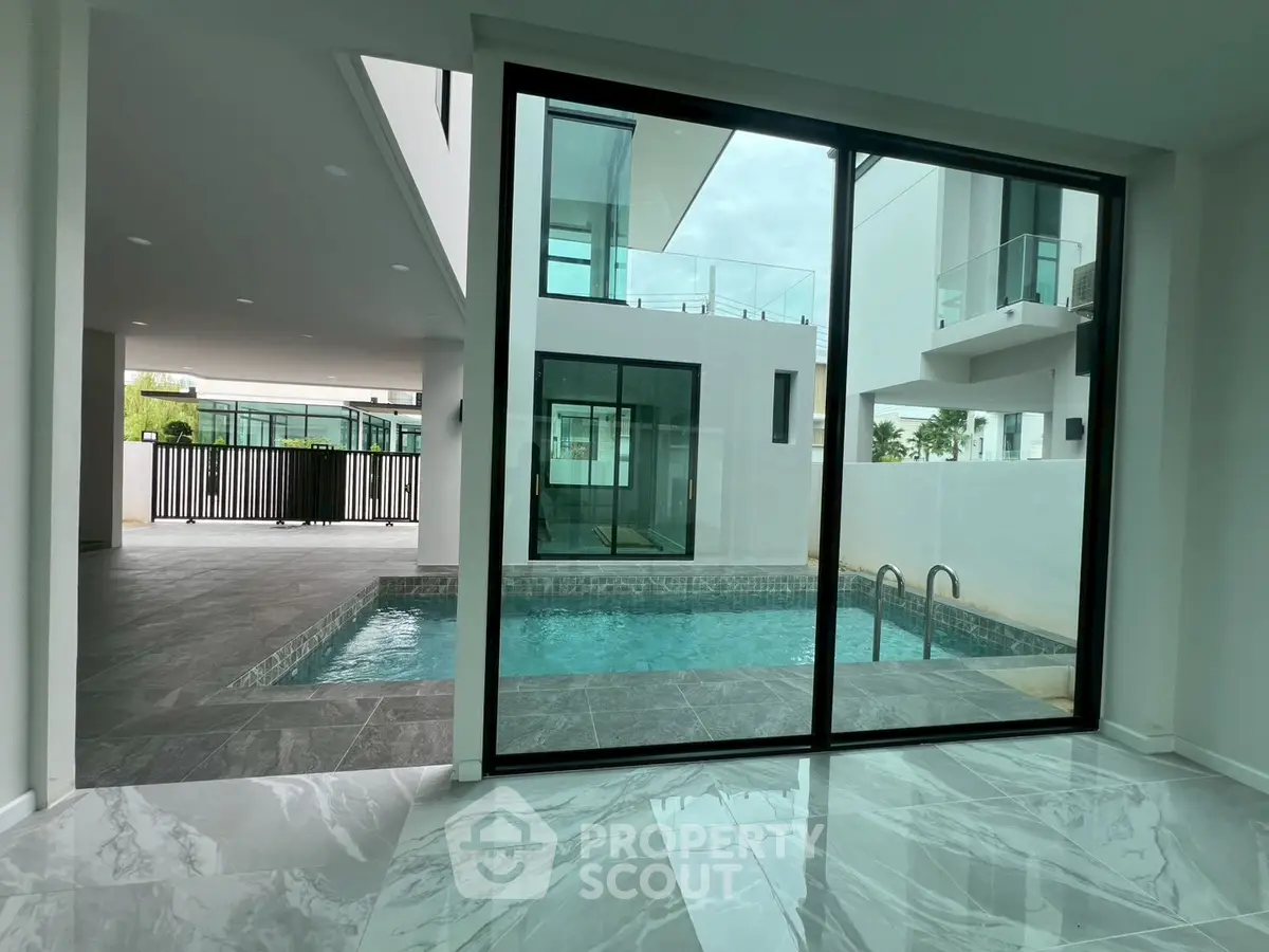 Luxurious modern home with private pool and sleek glass doors, perfect for elegant living.