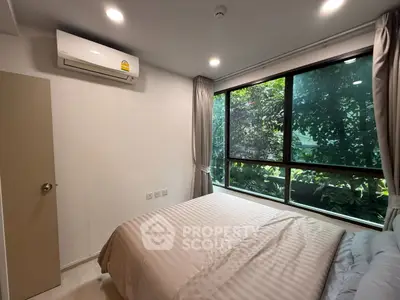 Cozy bedroom with large window and lush garden view, featuring modern air conditioning and elegant decor.