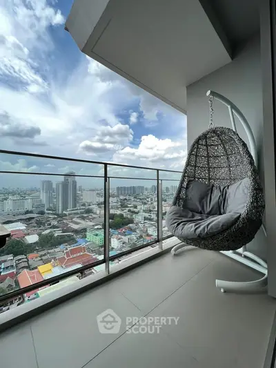 Stunning high-rise balcony with panoramic city view and cozy hanging chair.