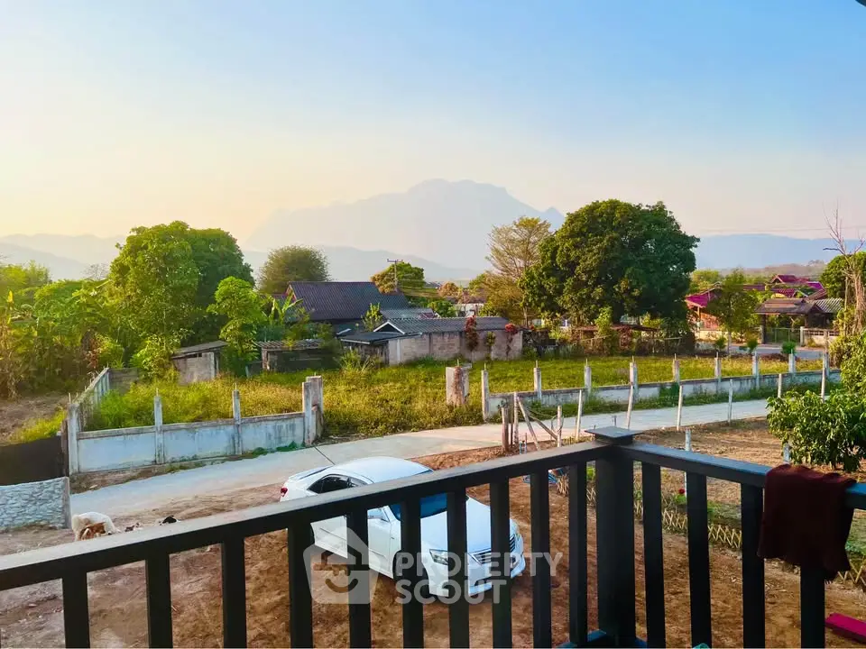 Scenic balcony view overlooking lush greenery and distant mountains, perfect for tranquil living.