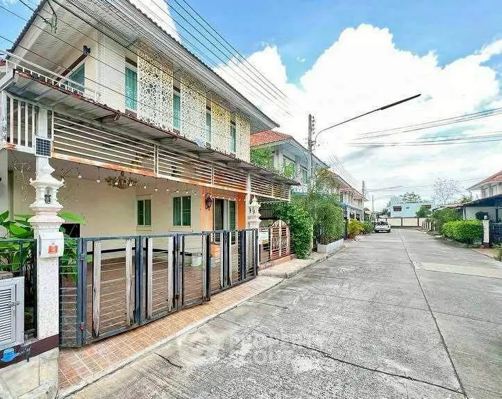 Charming two-story house with gated entrance in a serene neighborhood street view.