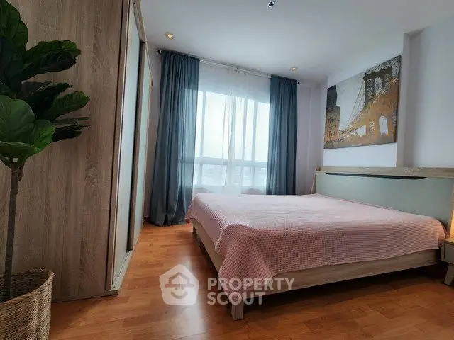 Spacious bedroom with modern decor and large window offering natural light.