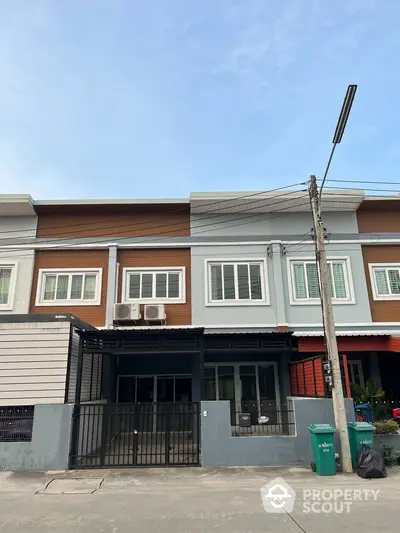 Modern townhouse exterior with clean lines and contemporary design in a suburban neighborhood.