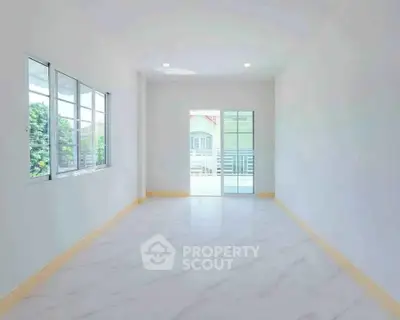 Spacious and bright empty room with large windows and balcony access, perfect for customization.