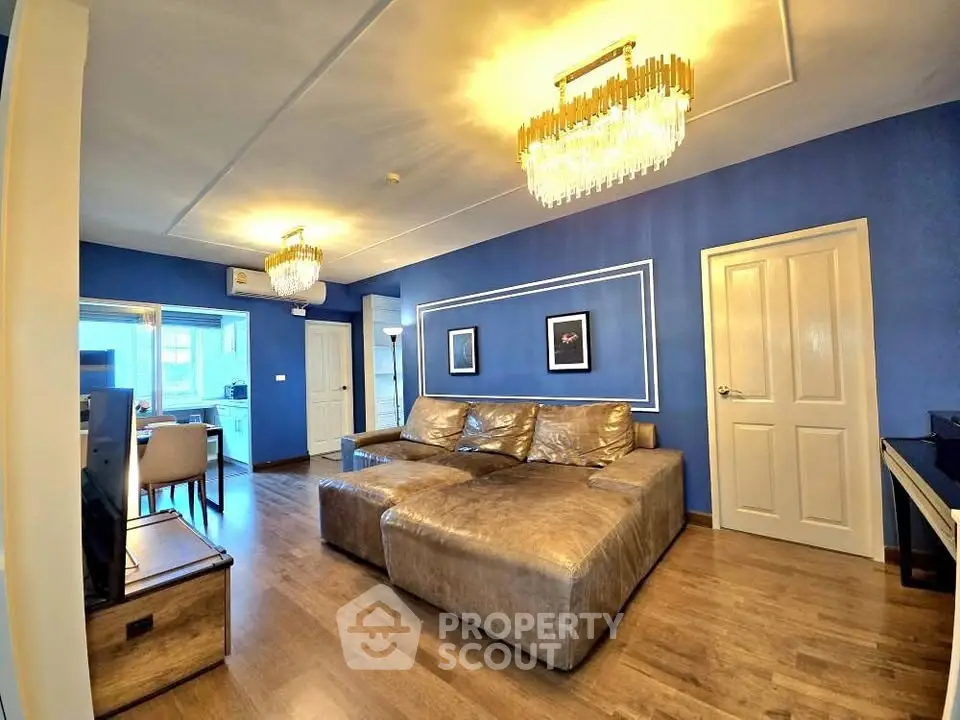 Luxurious living room with elegant chandeliers and plush leather sofa in modern apartment.