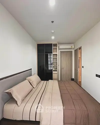 Modern bedroom with stylish decor and built-in wardrobe in a cozy apartment.