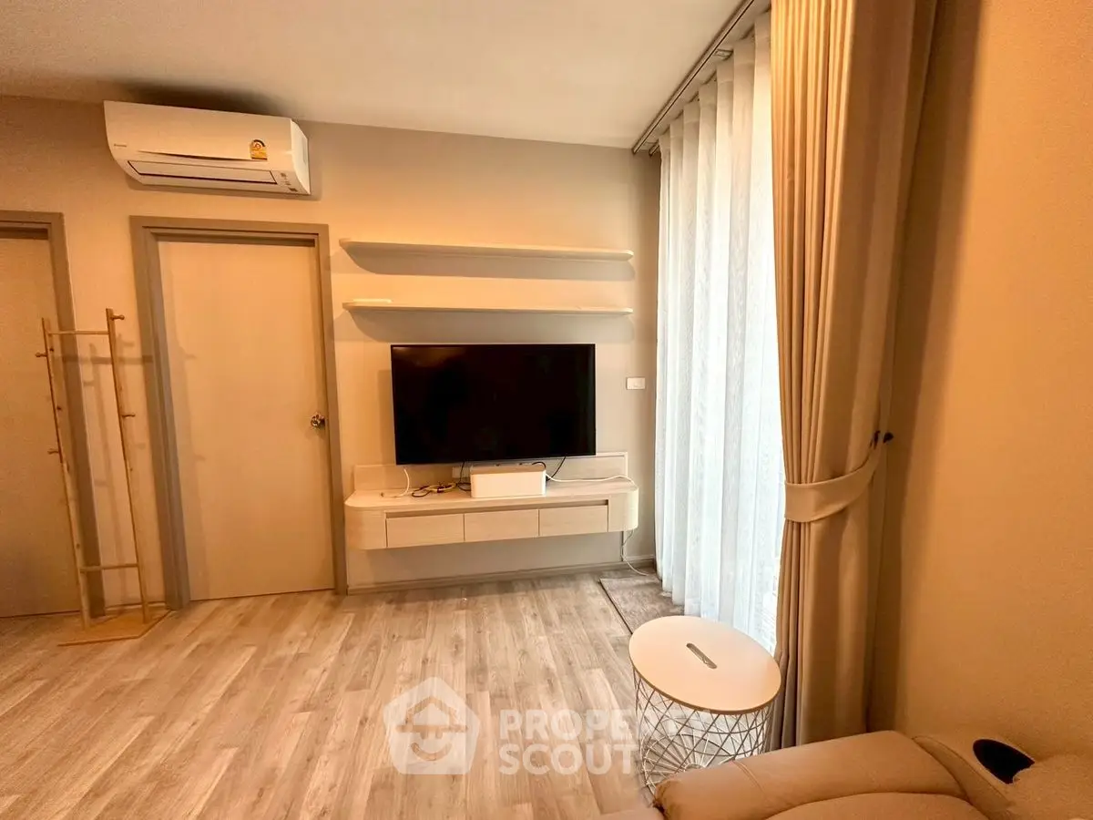 Modern living room with wall-mounted TV, air conditioning, and stylish decor.