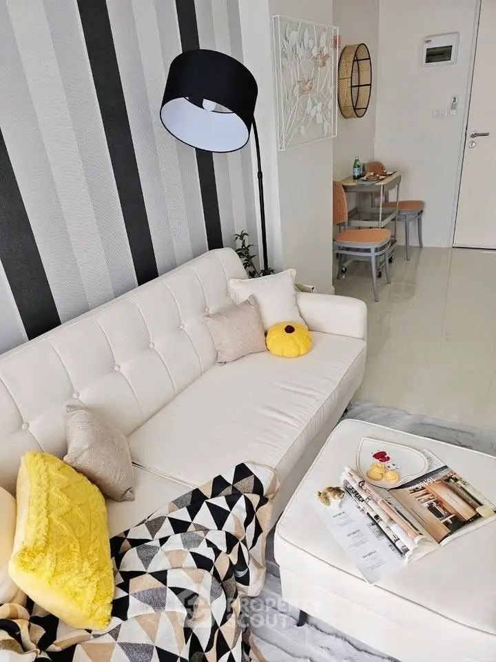 Stylish modern living room with cozy white sofa and chic decor accents.