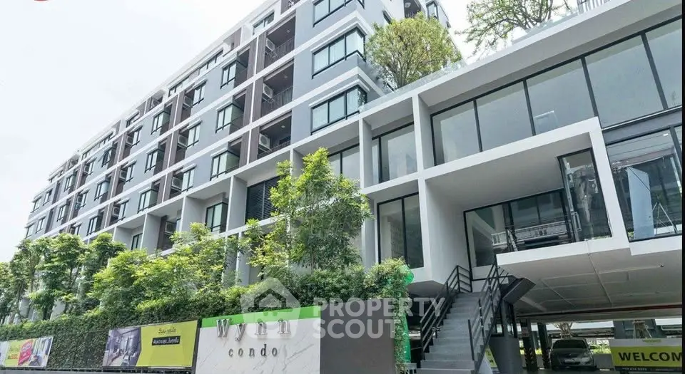 Modern condominium exterior with lush greenery and sleek architectural design.