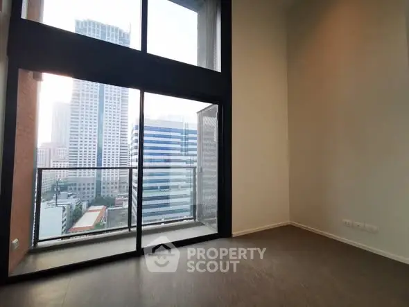 Spacious high-rise apartment with floor-to-ceiling windows and stunning city view.