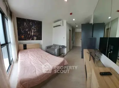 Modern bedroom with city view, featuring a cozy bed, sleek furniture, and large windows for natural light.