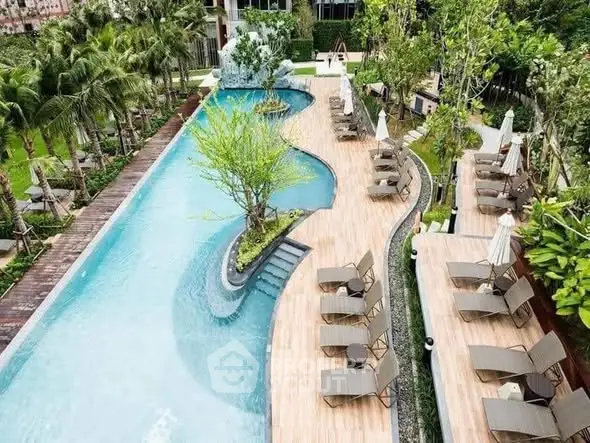 Luxurious outdoor pool area with sun loungers and lush greenery in a modern real estate setting.