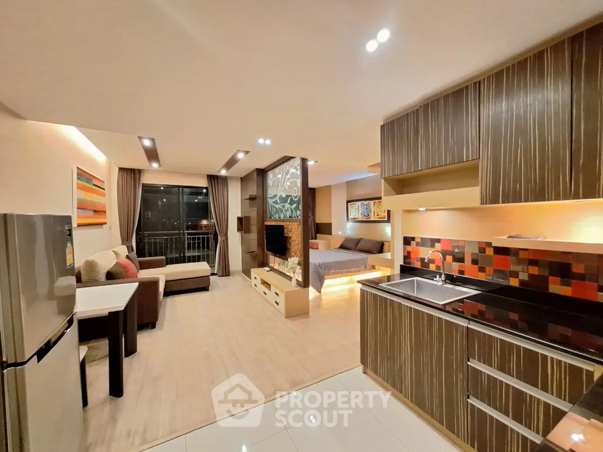 Modern open-plan living space with stylish kitchen and cozy living area, perfect for urban living.