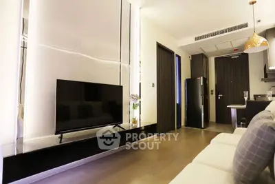 Modern living room with sleek TV setup and open kitchen layout