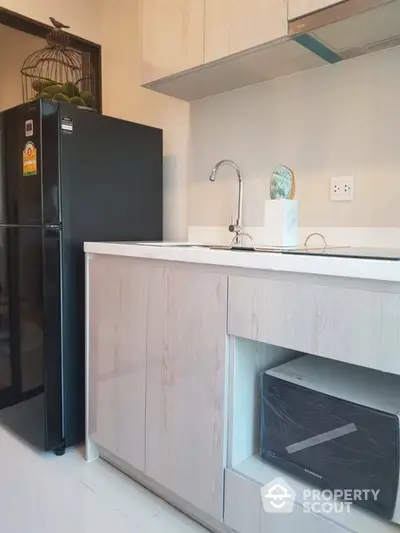 Modern kitchen with sleek cabinetry and black refrigerator