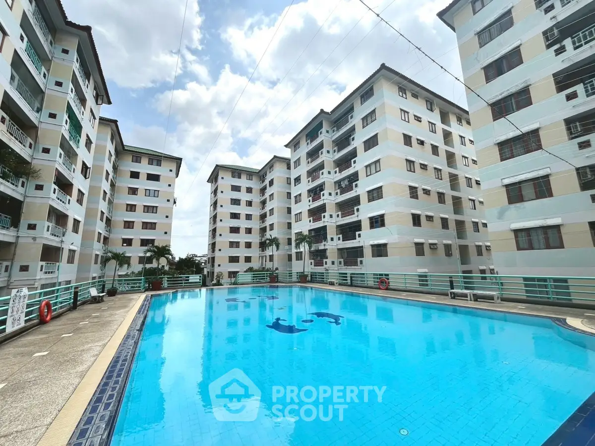 Spacious residential complex with a large swimming pool and modern architecture.