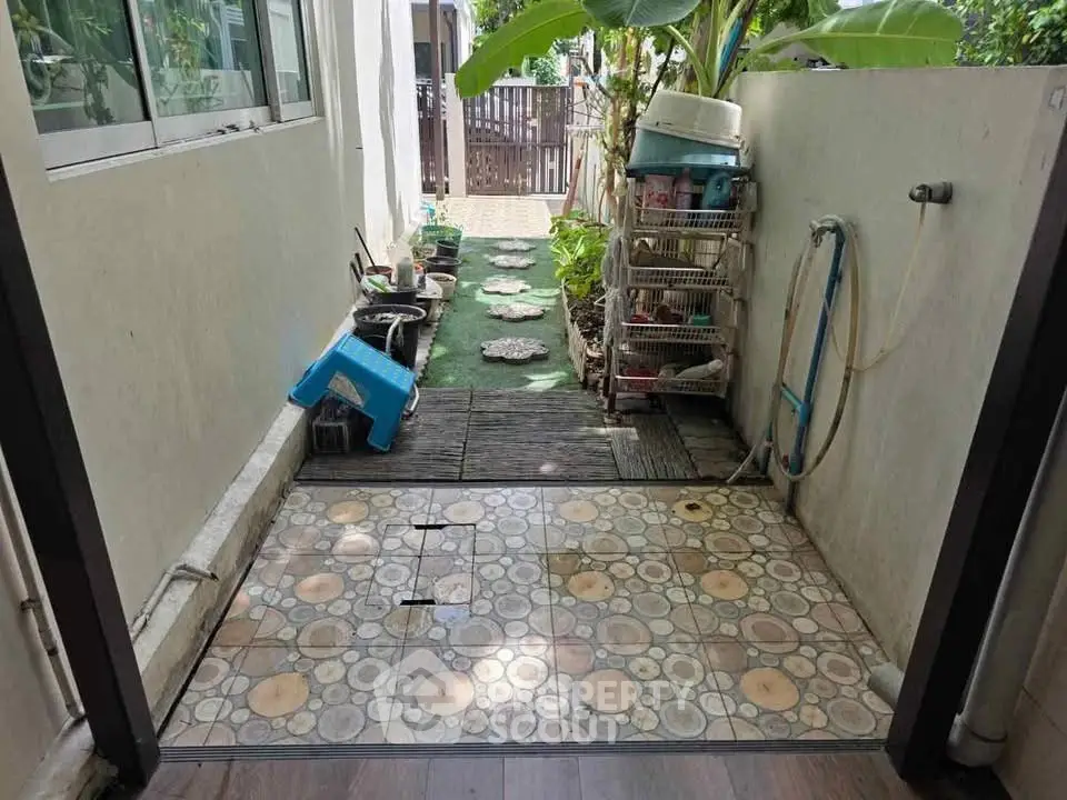 Charming outdoor garden path with tiled flooring and lush greenery, perfect for relaxation and gardening enthusiasts.