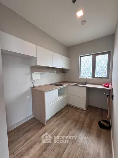 Modern kitchen with sleek cabinetry and wooden flooring