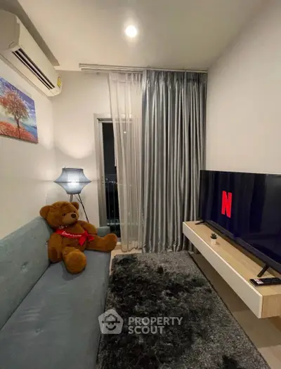 Cozy living room with modern decor, plush sofa, and large TV for entertainment.
