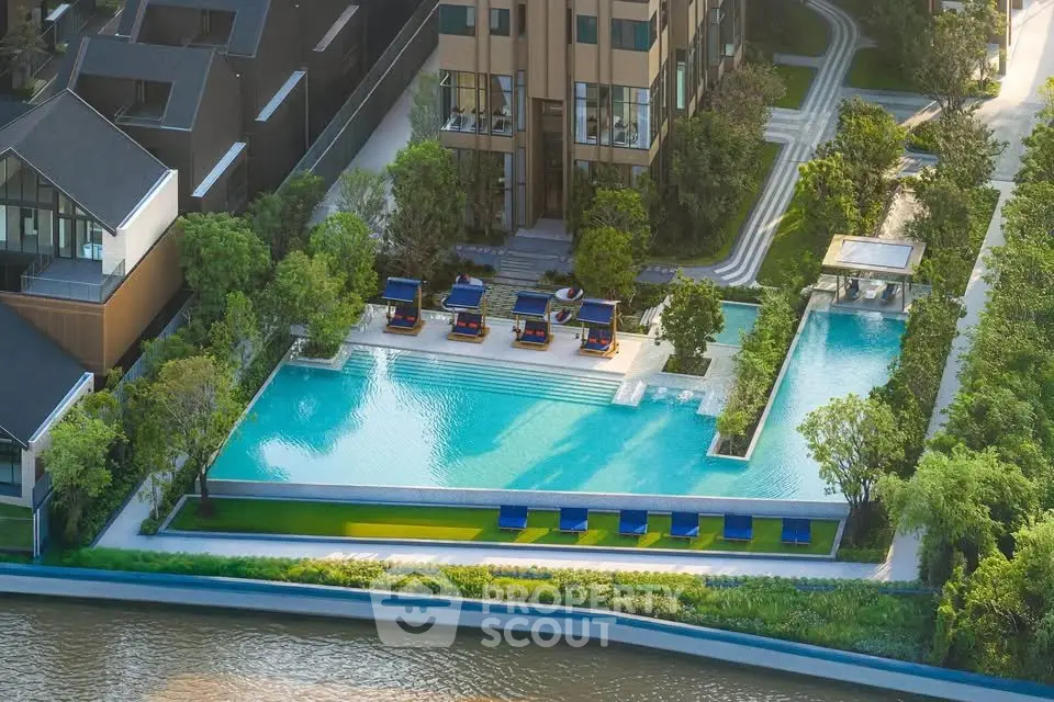 Luxurious riverside apartment complex with stunning pool and lush greenery