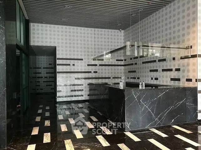 Luxurious modern building entrance with sleek marble design and contemporary lighting.