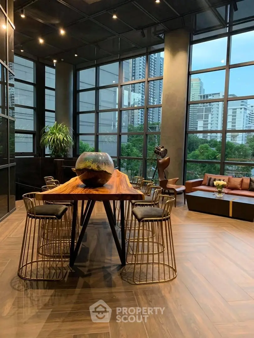 Luxurious modern living room with floor-to-ceiling windows and city view, featuring elegant furniture and stylish decor.