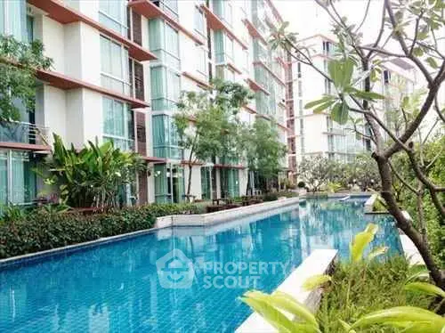 Luxurious condominium with stunning pool and lush greenery, perfect for modern living.
