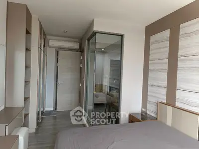 Modern bedroom with sleek design and glass partition in a stylish apartment.