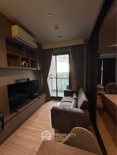 Modern living room with balcony view, featuring sleek furniture and wooden flooring.