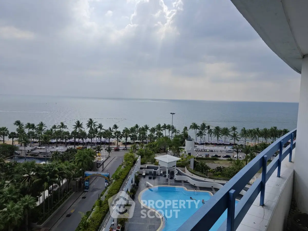 Stunning ocean view from a high-rise balcony with pool and palm-lined beach.