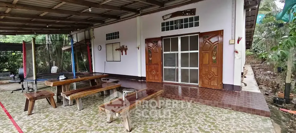 Charming rustic outdoor patio with wooden benches and tiled flooring, perfect for relaxation and gatherings.