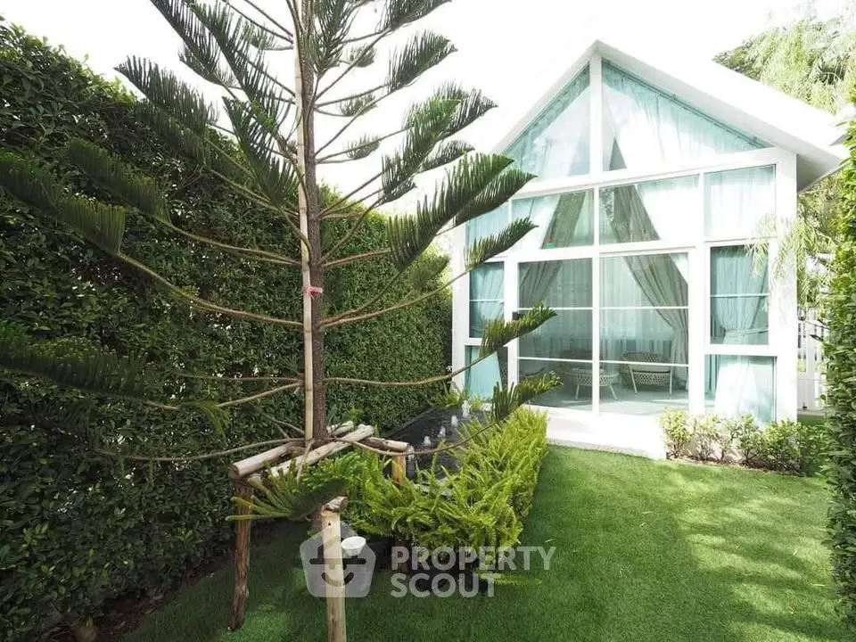 Charming modern house with lush garden and large glass windows