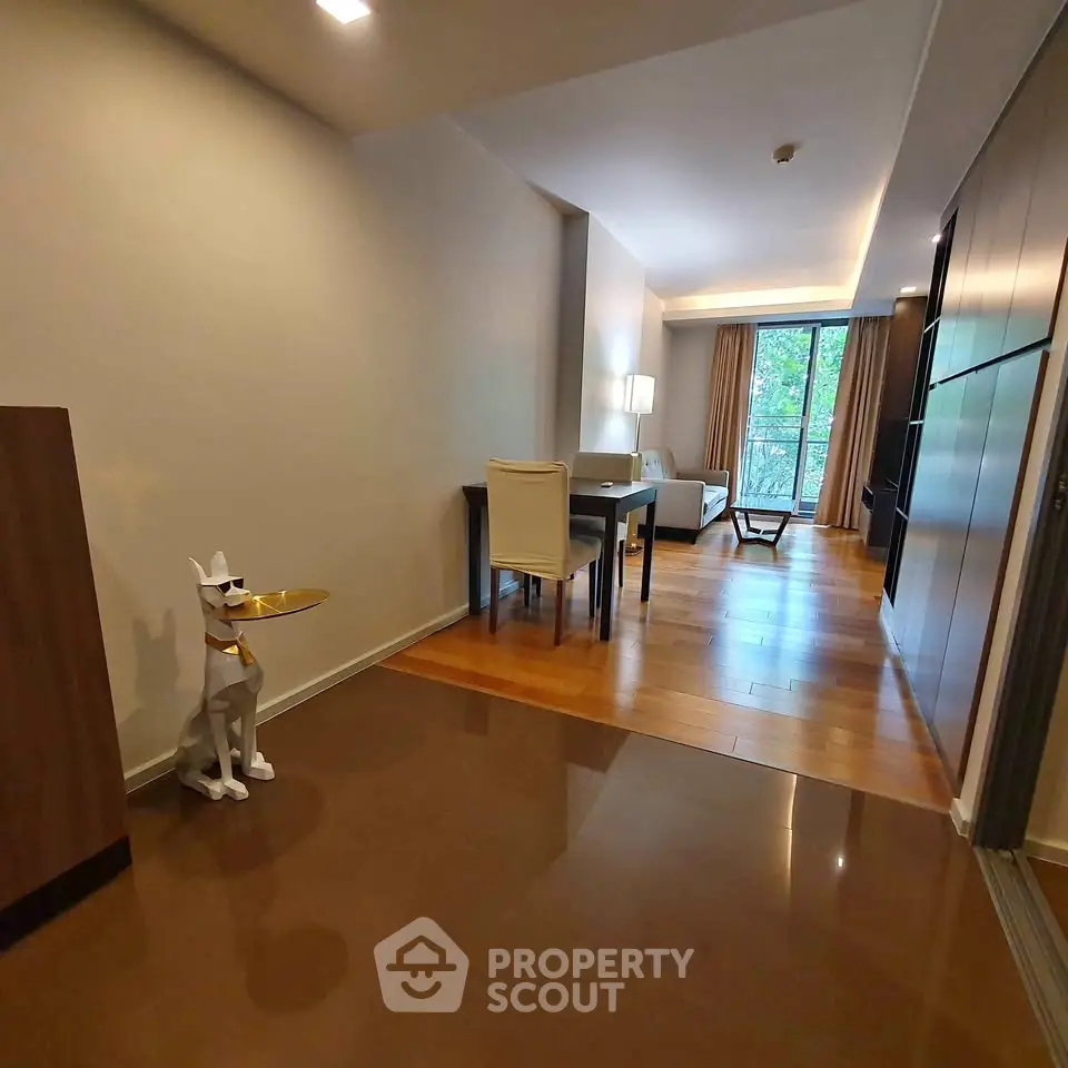 Modern living room with sleek design and wooden flooring, featuring a unique decorative statue.