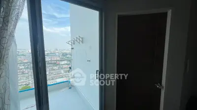 High-rise apartment balcony with stunning city view and sliding glass door.