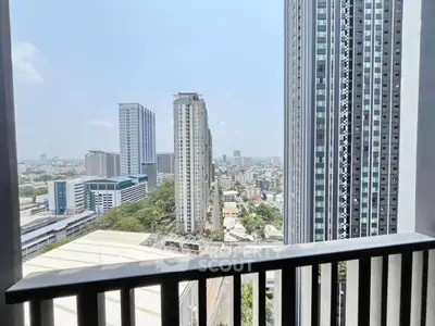 Stunning city view from high-rise balcony with modern skyscrapers and clear sky.