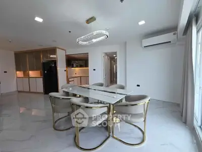 Modern dining area with elegant marble table and gold-accented chairs in a spacious open layout.