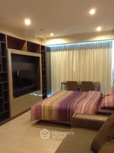 Modern bedroom with stylish decor and built-in entertainment center
