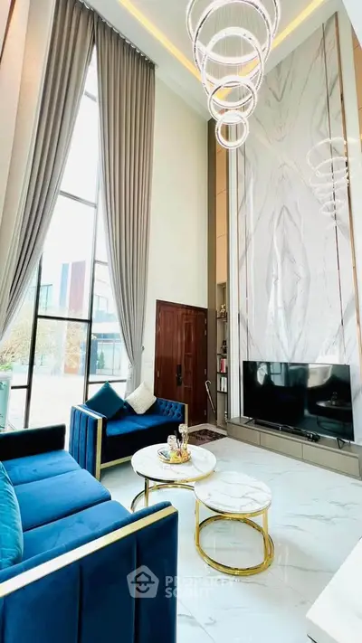 Luxurious high-ceiling living room with elegant decor and modern furniture, featuring a large window and stylish lighting.