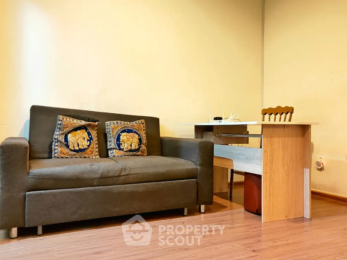 Cozy living room with stylish sofa and modern wooden desk, perfect for a comfortable home office setup.