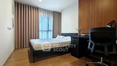 Modern bedroom with wooden flooring, sleek furniture, and large window with curtains.