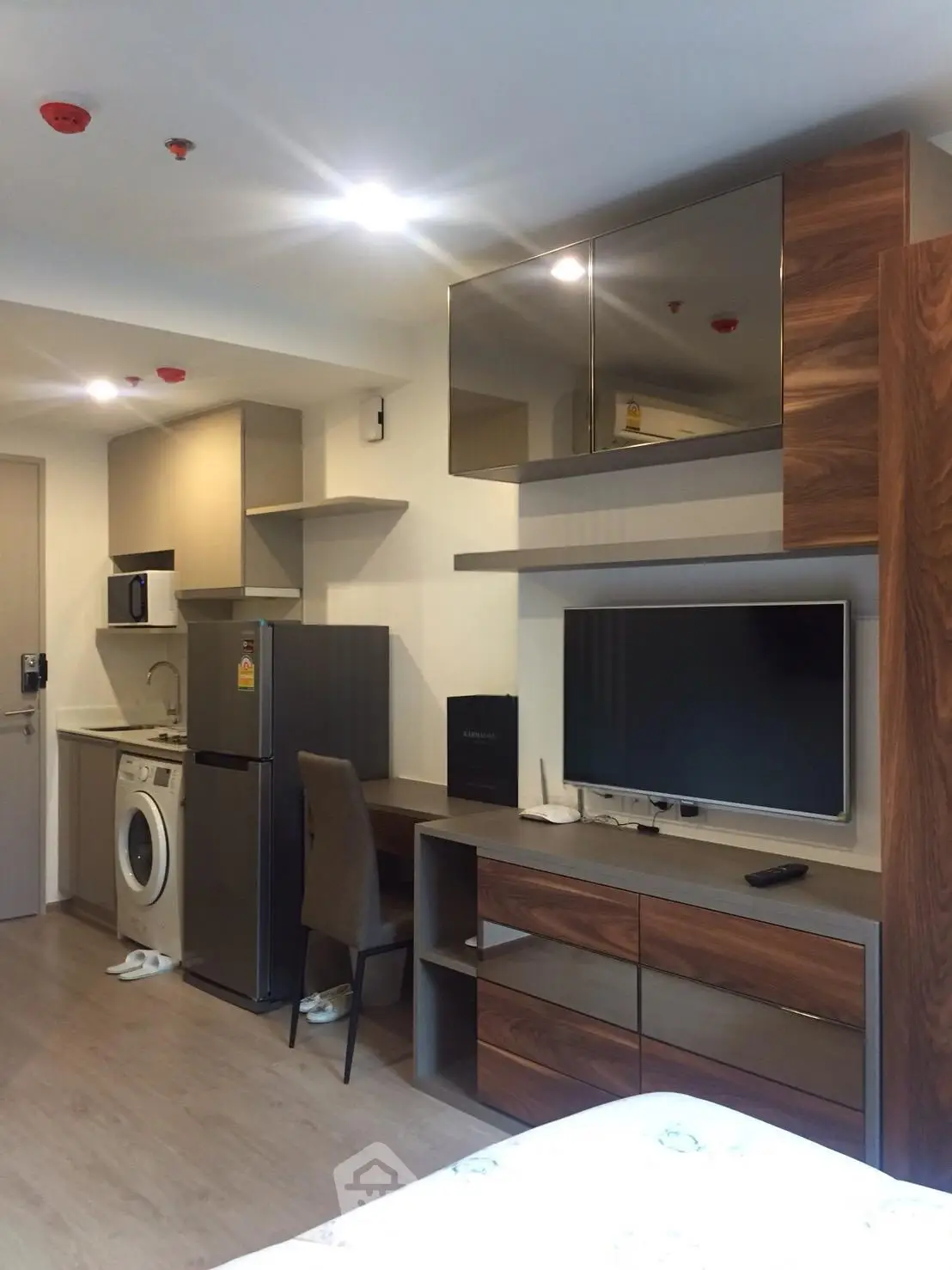 Modern studio apartment with integrated kitchen and living area, featuring sleek appliances and stylish decor.