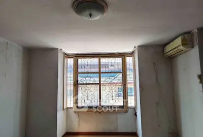 Spacious room with large window and air conditioning unit, ideal for customization.