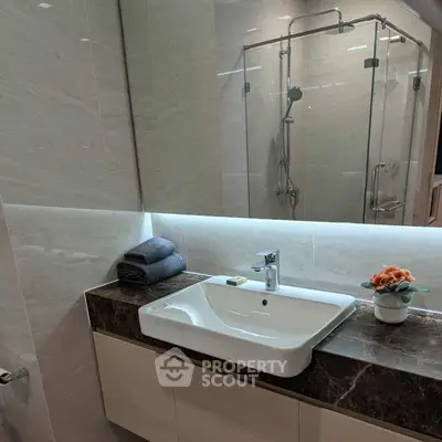 Modern bathroom with sleek sink and glass shower enclosure