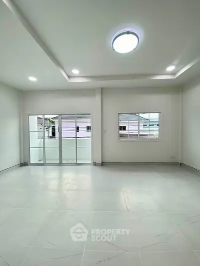 Spacious modern living room with large windows and sleek tile flooring
