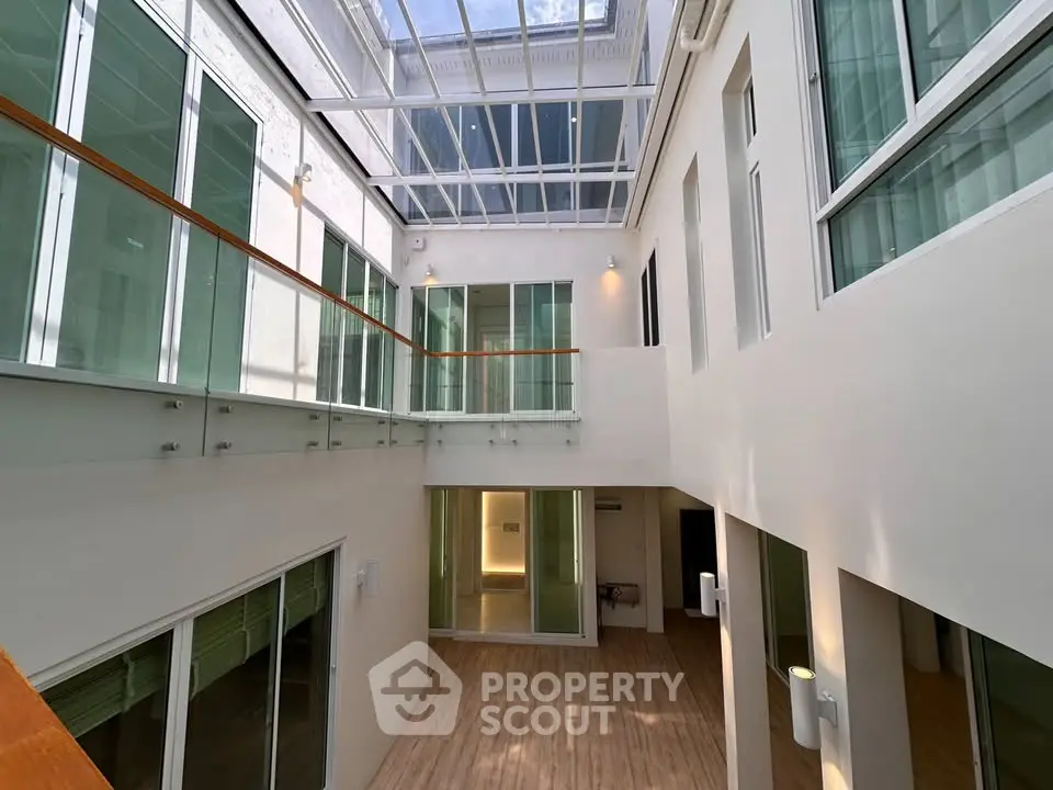 Stunning modern atrium with glass ceiling and sleek design, perfect for natural light lovers.