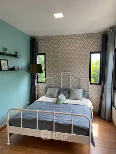 Charming bedroom with stylish decor and natural light, featuring a cozy bed and elegant wallpaper.