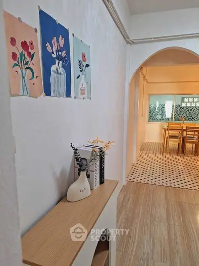 Charming hallway with artistic decor leading to a stylish dining area