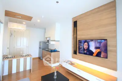 Modern living room with stylish wooden accents and wall-mounted TV in a cozy apartment.