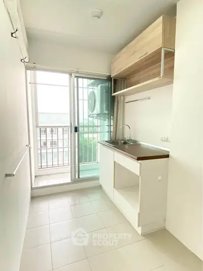 Compact kitchen with balcony view in modern apartment